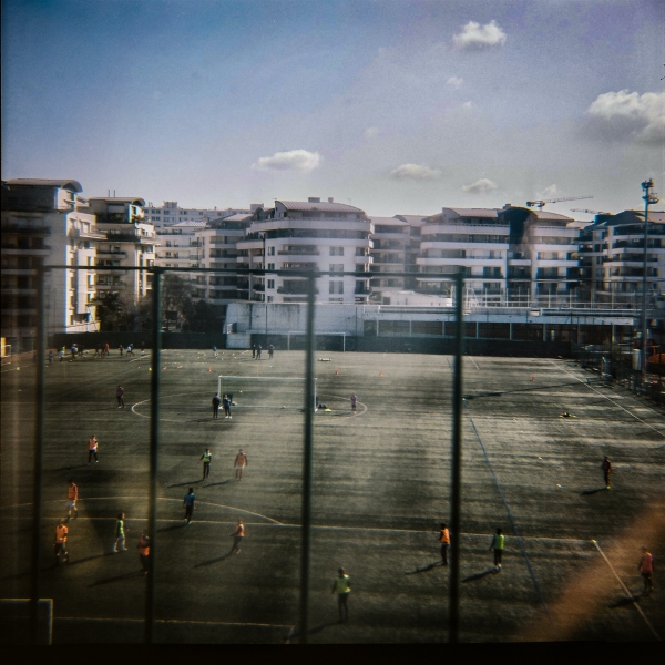 Illustration représentant un terrain de foot devant des immeubles